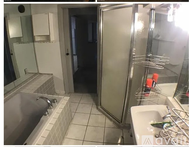 A bathroom with a glass shower door, a bathtub, and a sink.