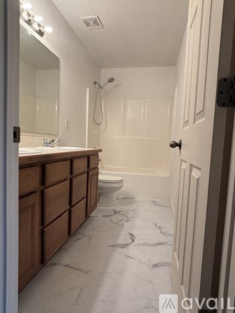 A bathroom with a marble floor and a white door.