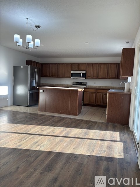 A kitchen with wooden cabinets and a refrigerator.