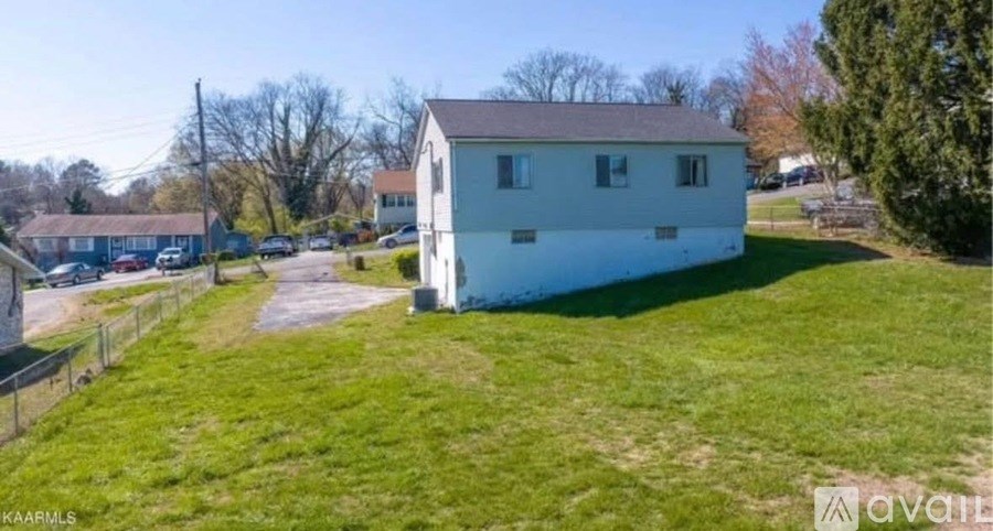 A white house with a green lawn in front of it.