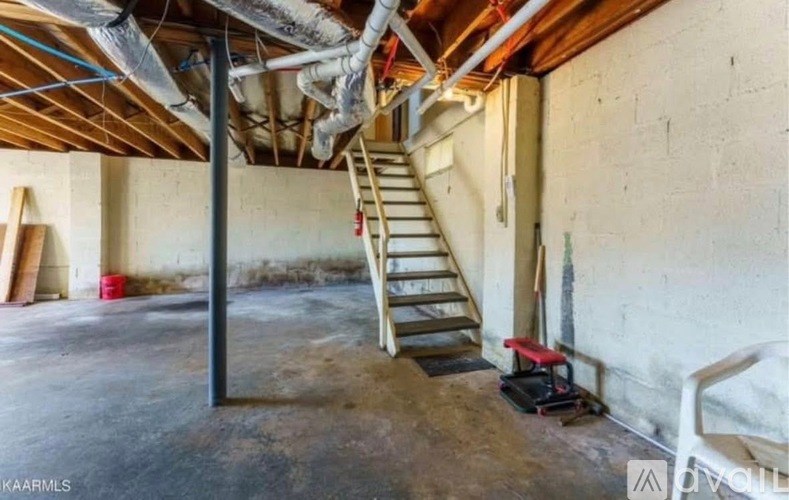 A room with a ladder and a vacuum cleaner.