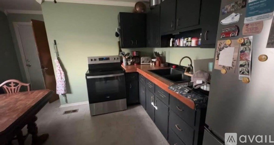 A kitchen with a refrigerator, oven, and sink.