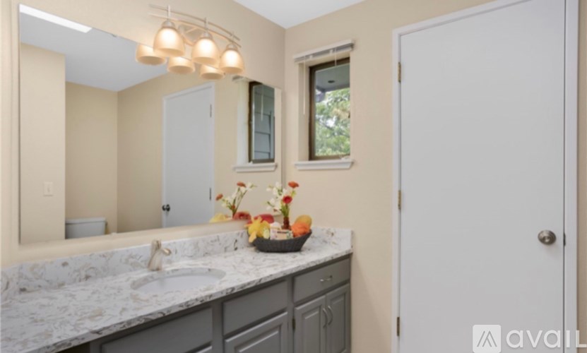 A bathroom with a marble countertop and a large mirror.