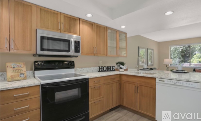 A kitchen with wooden cabinets and black appliances.