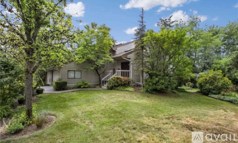 A house with a well-kept lawn and trees in the background.