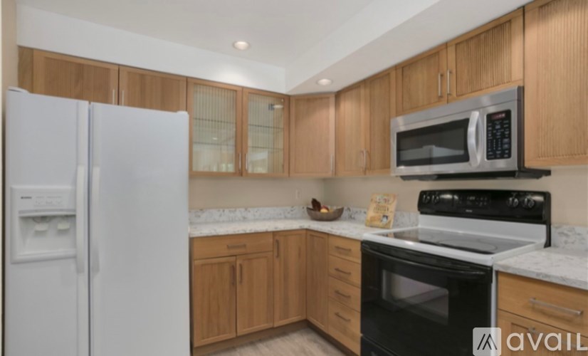 A kitchen with wooden cabinets and a white fridge.