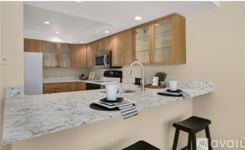 A kitchen with wooden cabinets and a marble countertop.