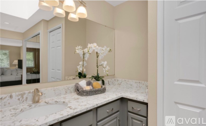 A bathroom with a marble countertop and a basket of flowers.