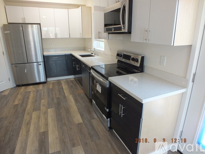 A kitchen with a black stove top oven and white countertops.