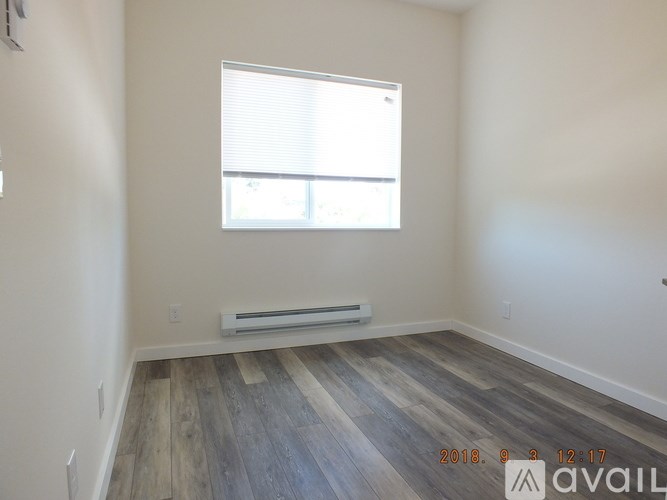 A room with a window and a wooden floor.