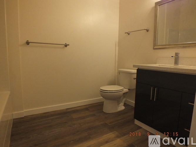 A bathroom with a toilet, sink, and a mirror.