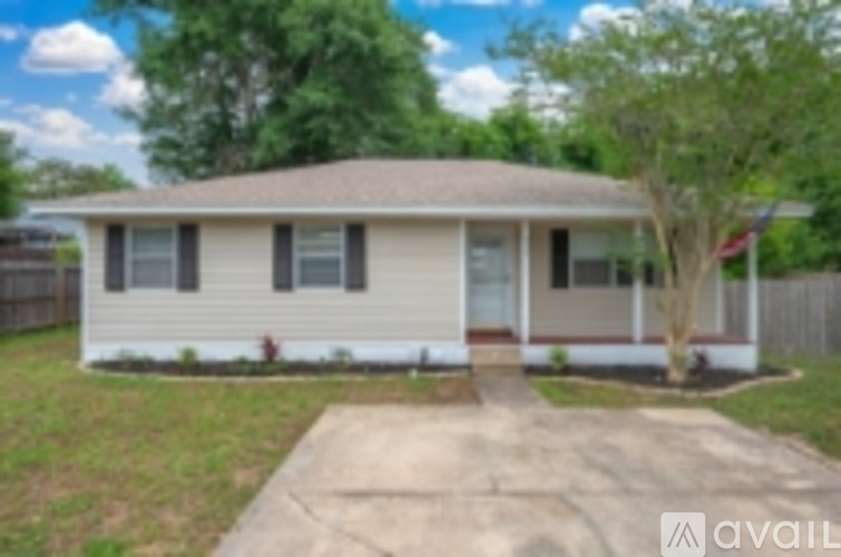 A house with a brown roof and a white fence.