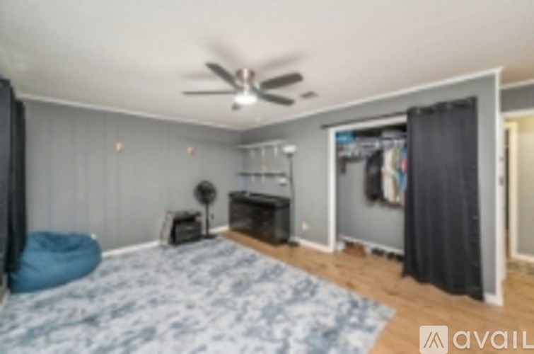 A room with a ceiling fan and a bed.