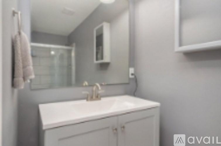 A bathroom with a white sink and a mirror above it.