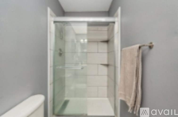 A bathroom with a toilet and a glass shower stall.