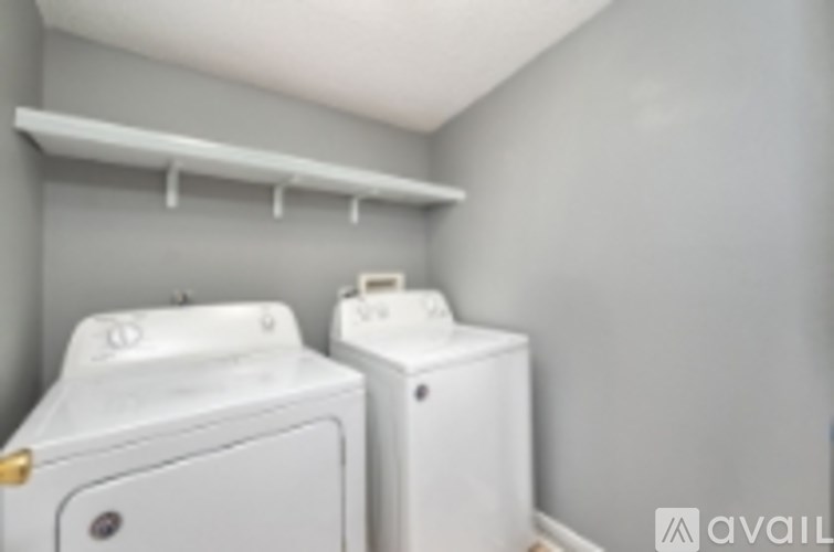 Two white front loading washing machines in a laundry room.