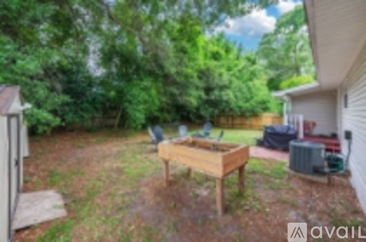 A backyard with a wooden table and chairs.