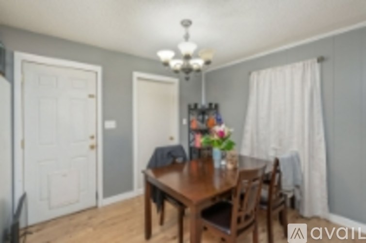 A dining room with a wooden table and chairs.