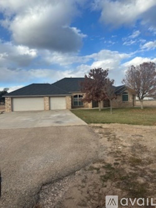 A house with a garage and a driveway in front of it.