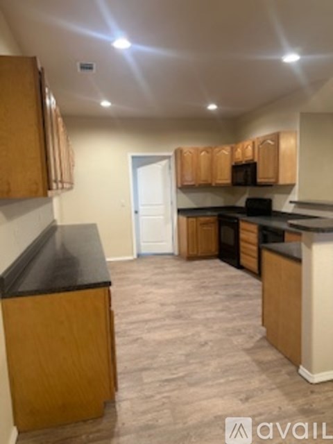 A kitchen with wooden cabinets and a black countertop.