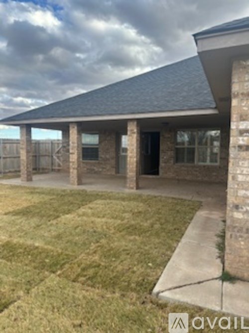 A house with a grey roof and a brown brick wall.