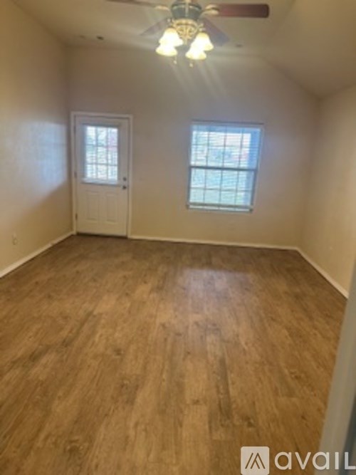 A room with wooden flooring and a ceiling fan.