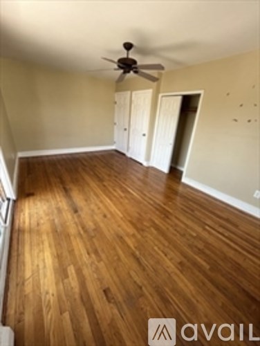 A room with wooden floors and a ceiling fan.