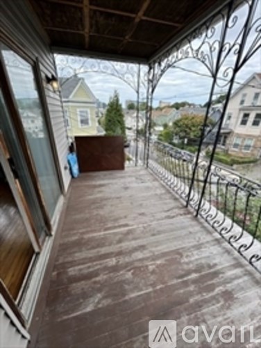 A balcony with a metal railing and a view of houses.