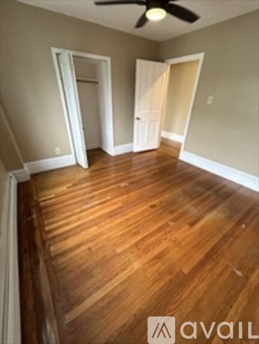 A room with wooden floors and a ceiling fan.