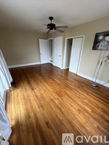A room with wooden floors and a ceiling fan.