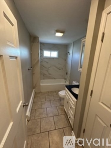 A bathroom with a toilet, sink, and bathtub.