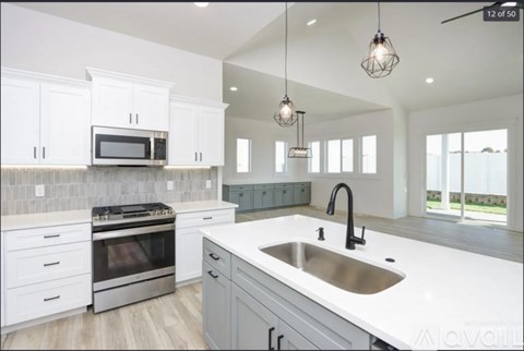 A modern kitchen with white cabinets and a large island.