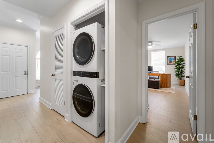 A modern laundry room with a washer and dryer built into the cabinetry.