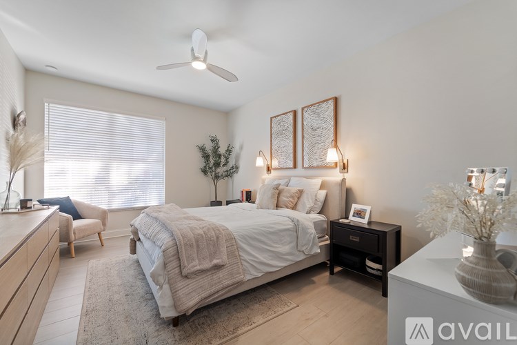 A well-lit bedroom with a large bed and a ceiling fan.