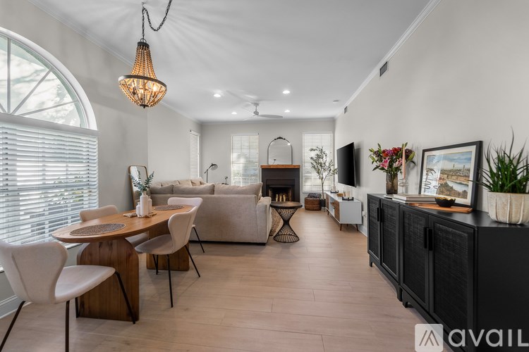 A modern living room with a dining area and a kitchenette.