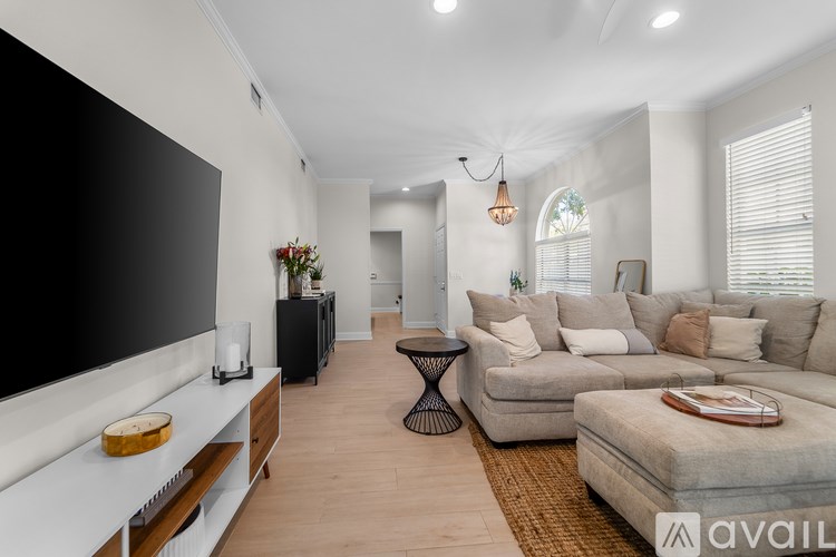 A modern living room with a large television and comfortable seating.