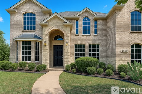 A large house with a black door and windows is for sale.