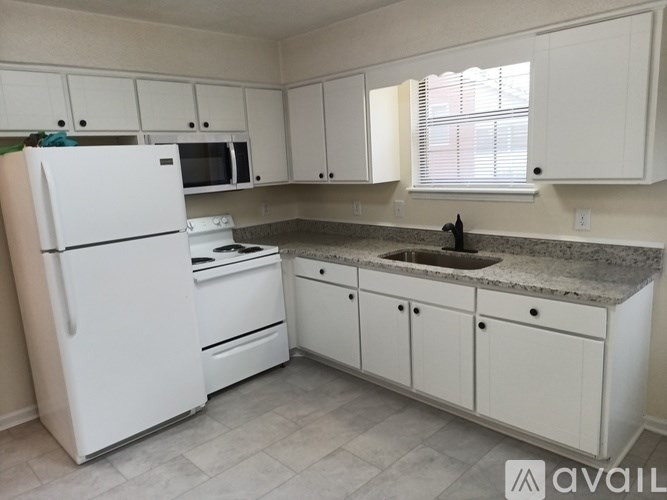 A kitchen with white appliances and cabinets.