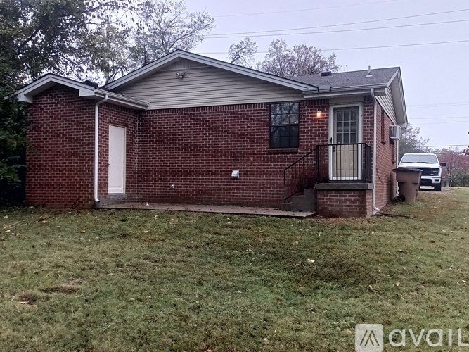 A small red brick house with a white door and a window.