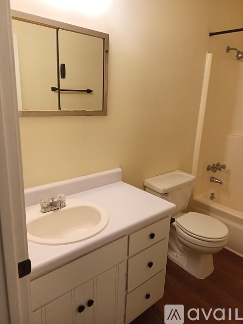 A bathroom with a sink, toilet and bathtub.