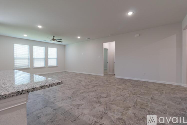 A spacious room with a marble floor and a ceiling fan.