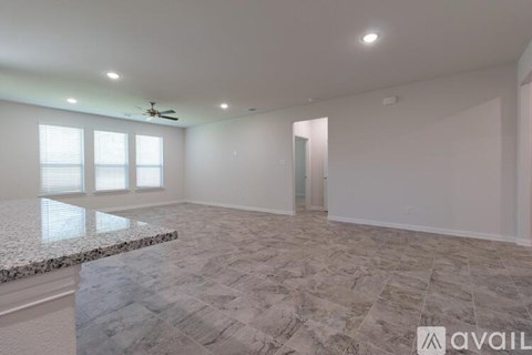 A spacious room with a marble floor and a ceiling fan.