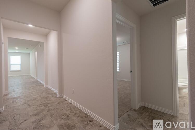 A long hallway with tiled floors and white walls.
