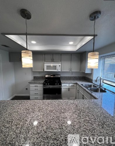 A kitchen with a granite countertop and a sink.