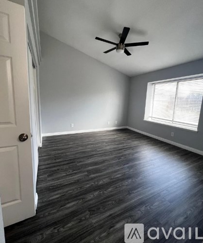 A room with a ceiling fan and a door.