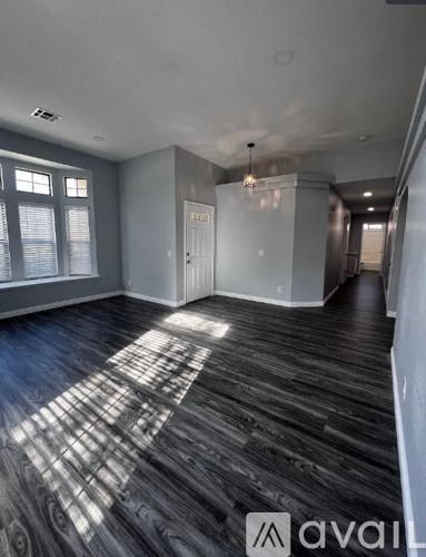 A room with wooden flooring and a large window.