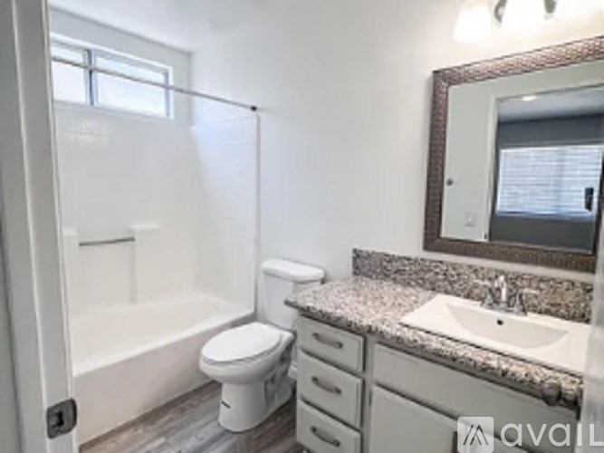 A bathroom with a toilet, sink, and mirror.
