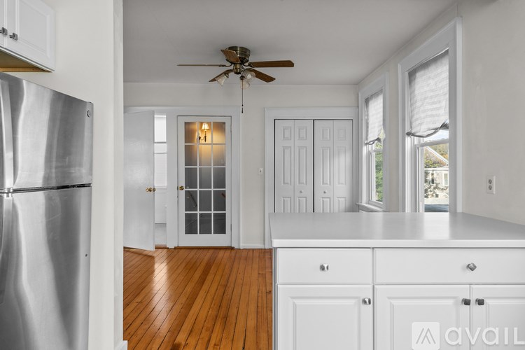 A kitchen with white cabinets and a silver refrigerator.