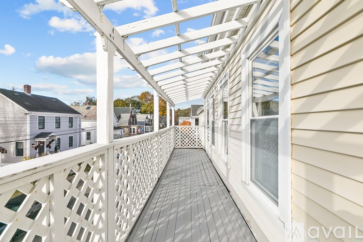 A white deck with a lattice design and a white pergola.