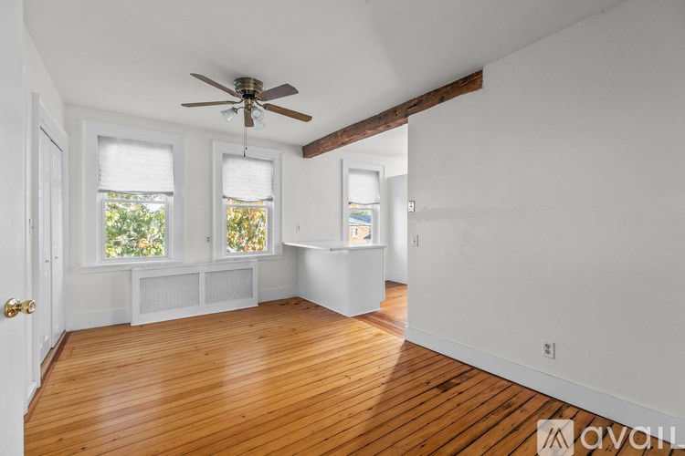A room with wooden floors and a ceiling fan.